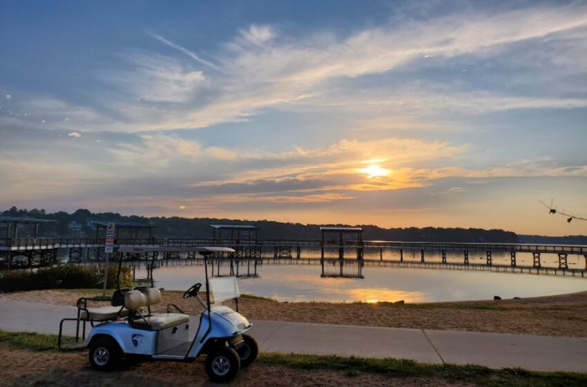 Golf cart near a waterbody at sunset time